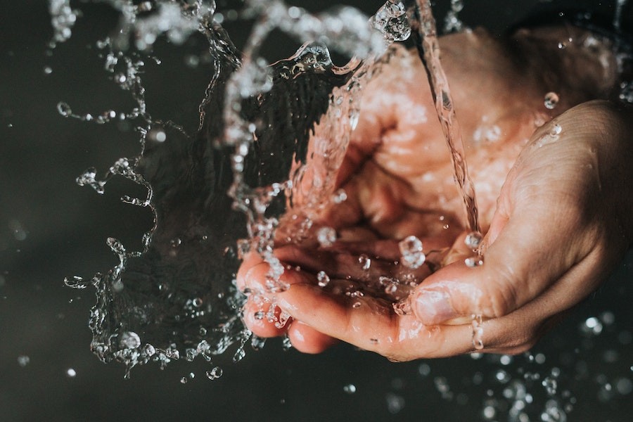 closeup shot of hands beneath running, splashing water