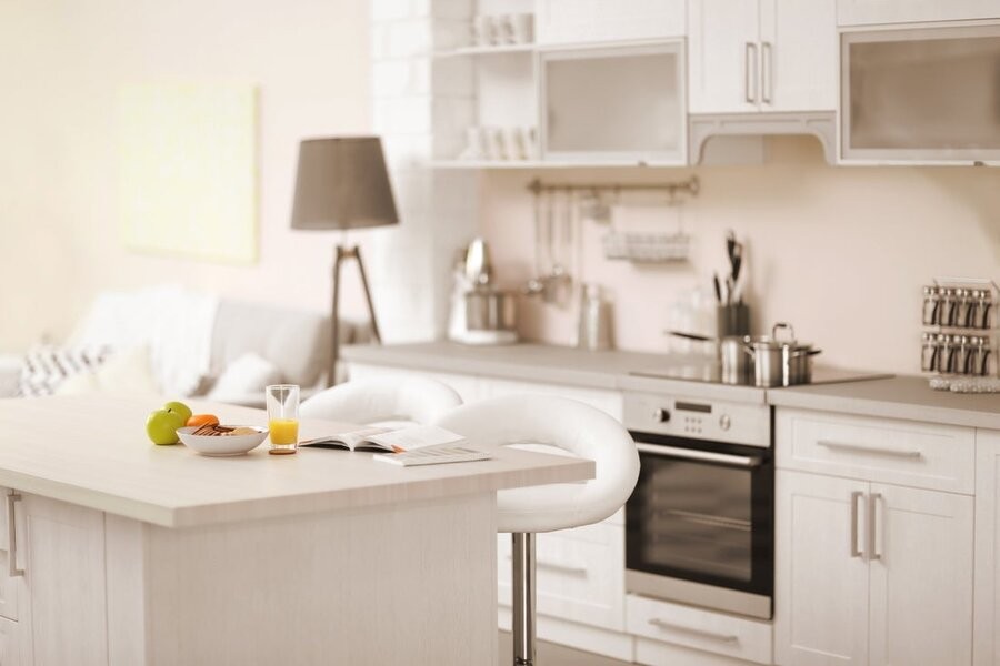 A bright kitchen space with a seating area and counter at the forefront.