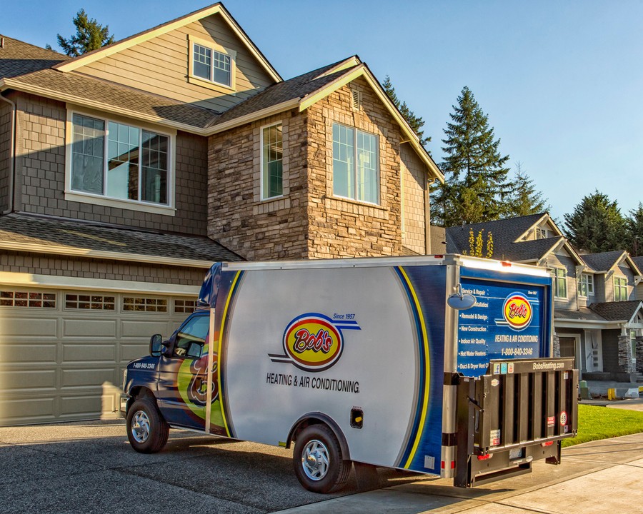 Bob’s Heating & Air Conditioning service truck in front of a brick neighborhood home