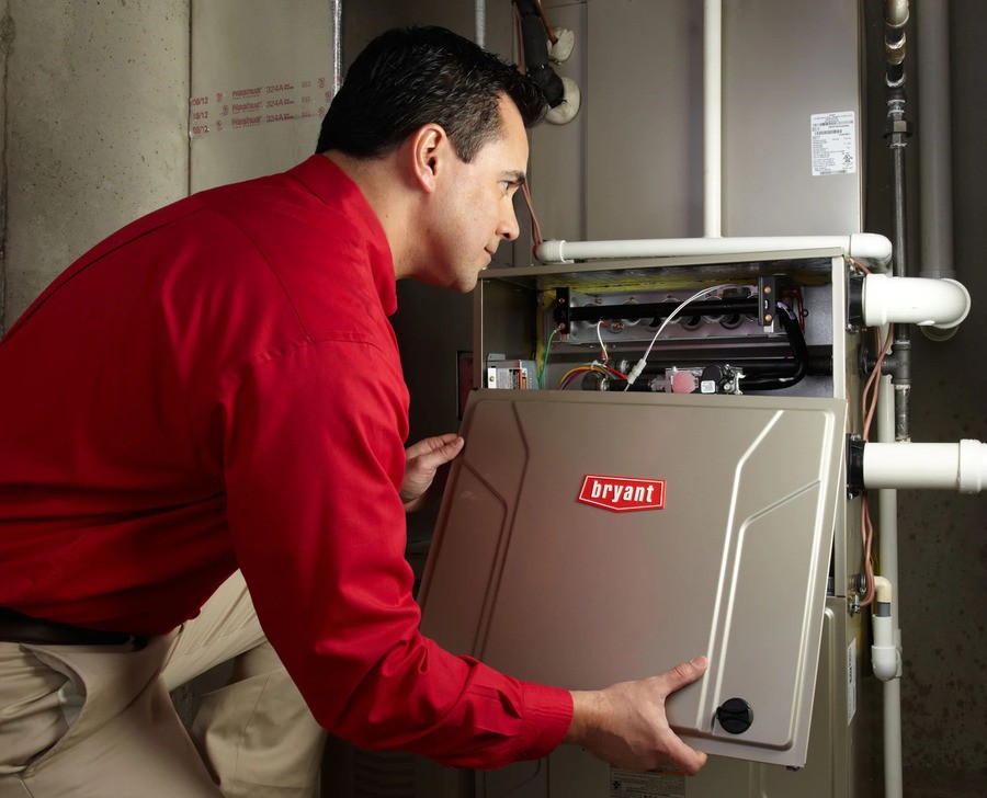 A member of the Bob's Heating team installing a Bryant furnace system.