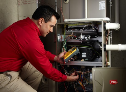 A Bryant furnace technician works on troubleshooting and installing a new furnace.