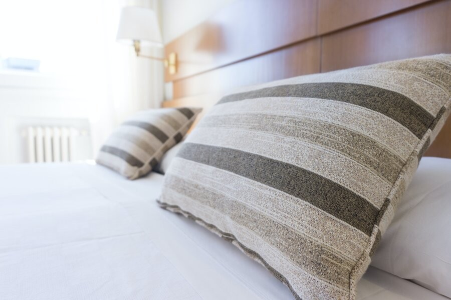 A freshly made bed representing the clean, refreshing atmosphere via professional duct services.