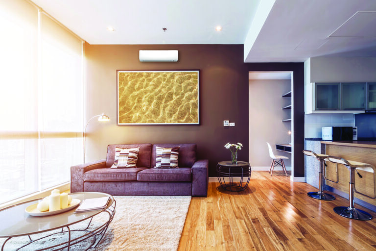 A living room with a ductless wall unit above the sofa