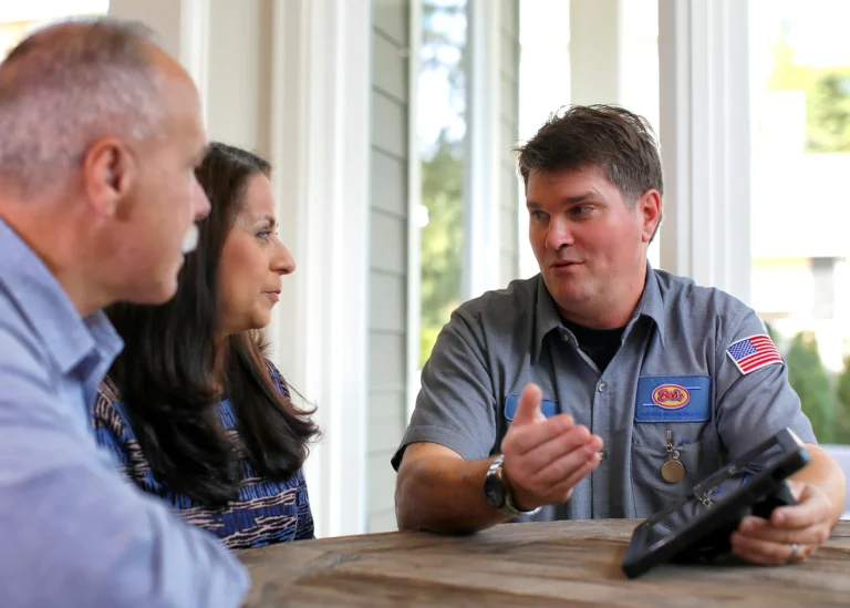 A Bob’s technician talking with two homeowners at their kitchen table