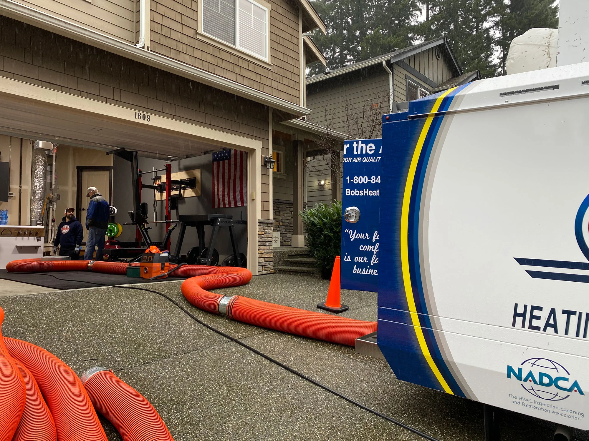 A Bob’s duct cleaning truck with hoses run to a home